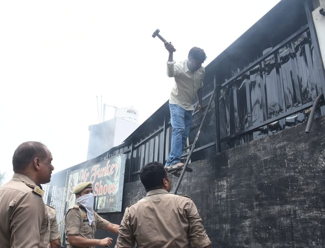 जूतों के शोरूम व गोदाम में लगी और राहत कार्य में जुटी दमकल की टीम। 