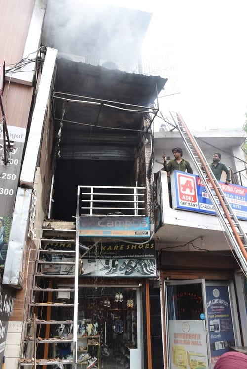 जूतों के शोरूम व गोदाम में लगी और राहत कार्य में जुटी दमकल की टीम। 