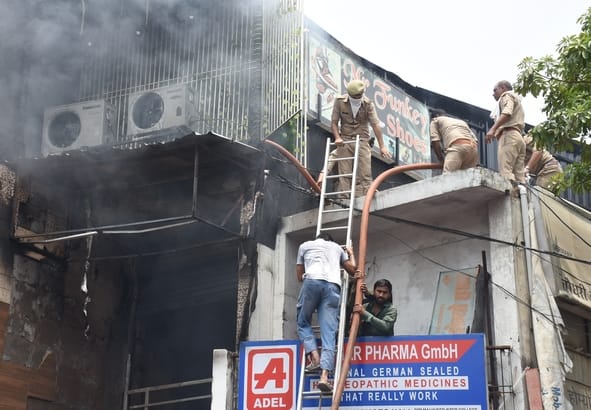 जूतों के शोरूम व गोदाम में लगी और राहत कार्य में जुटी दमकल की टीम। 