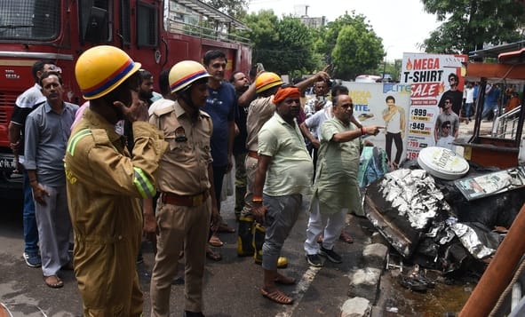 जूतों के शोरूम व गोदाम में लगी और राहत कार्य में जुटी दमकल की टीम। 