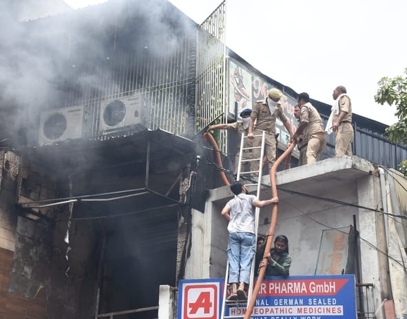 जूतों के शोरूम व गोदाम में लगी और राहत कार्य में जुटी दमकल की टीम। 