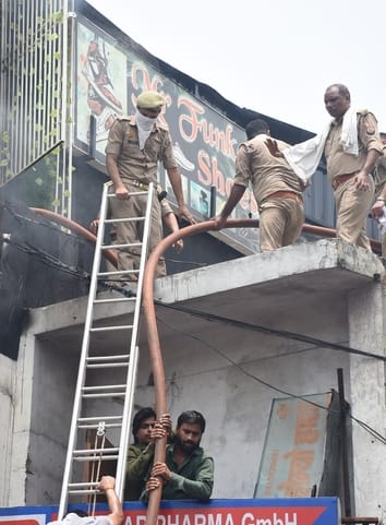 जूतों के शोरूम व गोदाम में लगी और राहत कार्य में जुटी दमकल की टीम। 