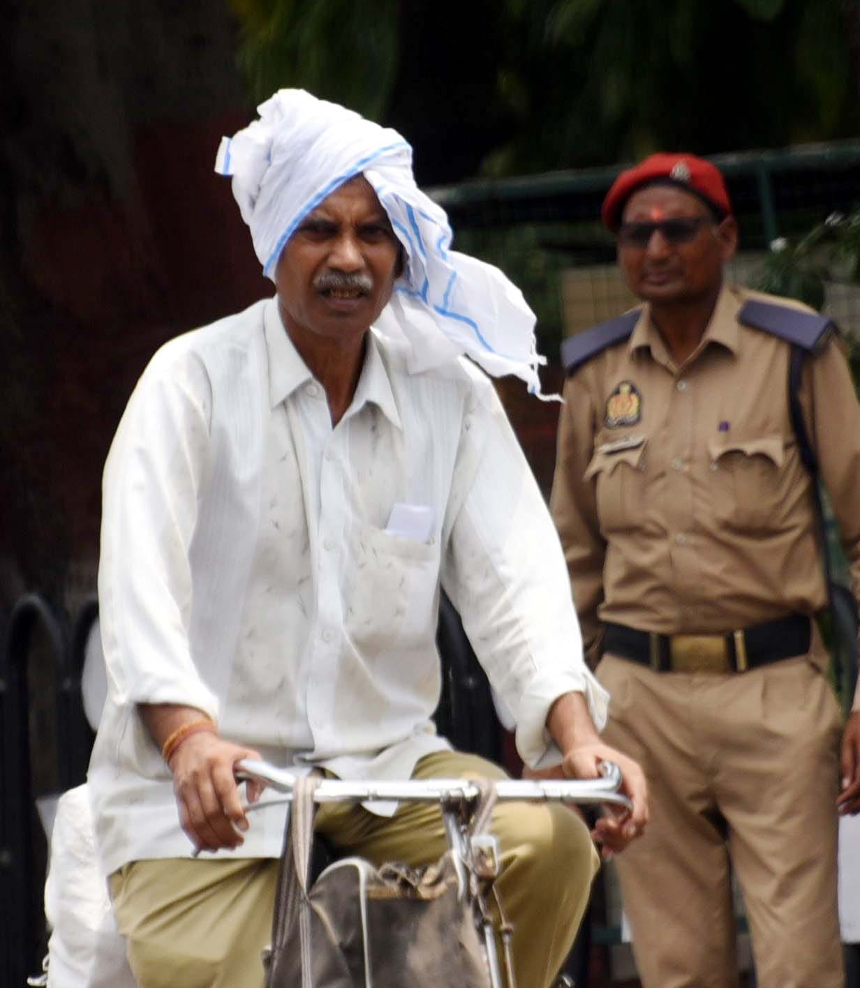सोमवार को गर्मी और उमस से परेशान नजर आए लोग। 