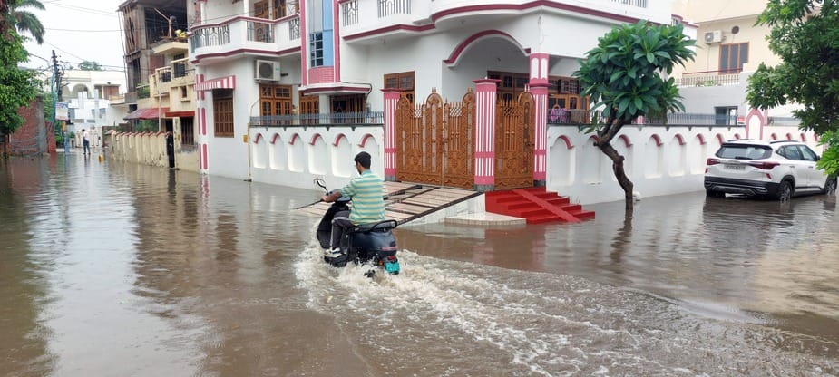 बिजनौर में ज्ञान विहार कालोनी के बाहर हुए जलभराव से निकलते वाहन। संवाद