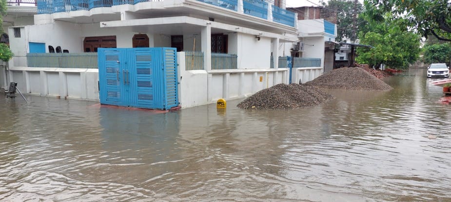 बिजनौर में ज्ञान विहार कालोनी के बाहर हुए जलभराव से निकलते वाहन। संवाद