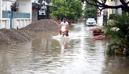 बिजनौर में ज्ञान विहार कालोनी के बाहर हुए जलभराव से निकलते वाहन। संवाद