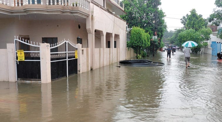 बिजनौर में ज्ञान विहार कालोनी के बाहर हुए जलभराव से निकलते वाहन। संवाद