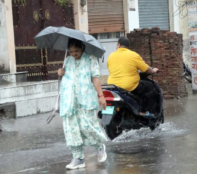 बिजनौर में ज्ञान विहार कालोनी के बाहर हुए जलभराव से निकलते वाहन। संवाद