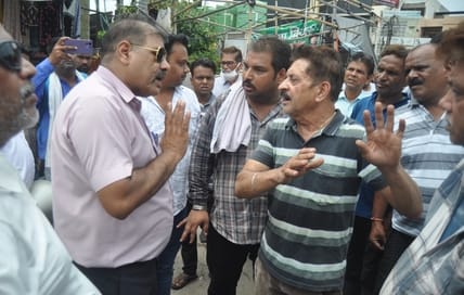 गोल मार्केट में जेसीबी मशीन के आगे खड़े दुकानदार। संवाद गोल मार्केट में जेसीबी मशीन के आगे खड़े दुकानदार। संवाद