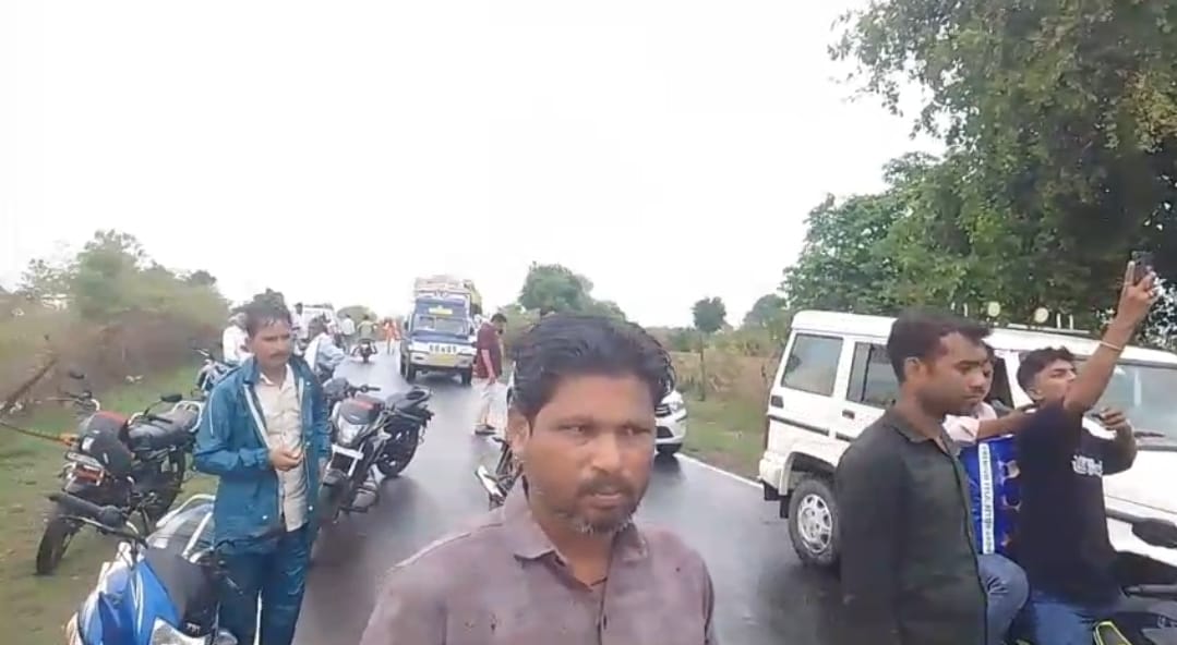 पुल से बहते पानी के उतरने का इंतजार करते राहगीर