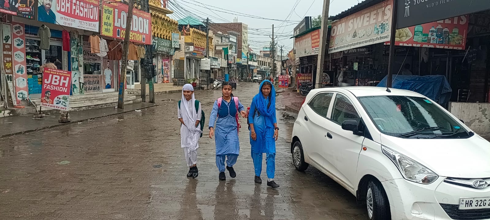 बारिश के दौरान घर को लौटती स्कूली छात्राएं। संवाद बारिश के दौरान घर को लौटती स्कूली छात्राएं। संवाद