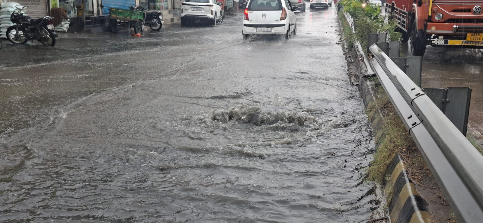 विश्वकर्मा चौक पर नाला ओवरफ्लो होने सड़क पर भरा पानी और निकलते वाहन। संवाद विश्वकर्मा चौक पर नाला ओवरफ्लो होने सड़क पर भरा पानी और निकलते वाहन। संवाद