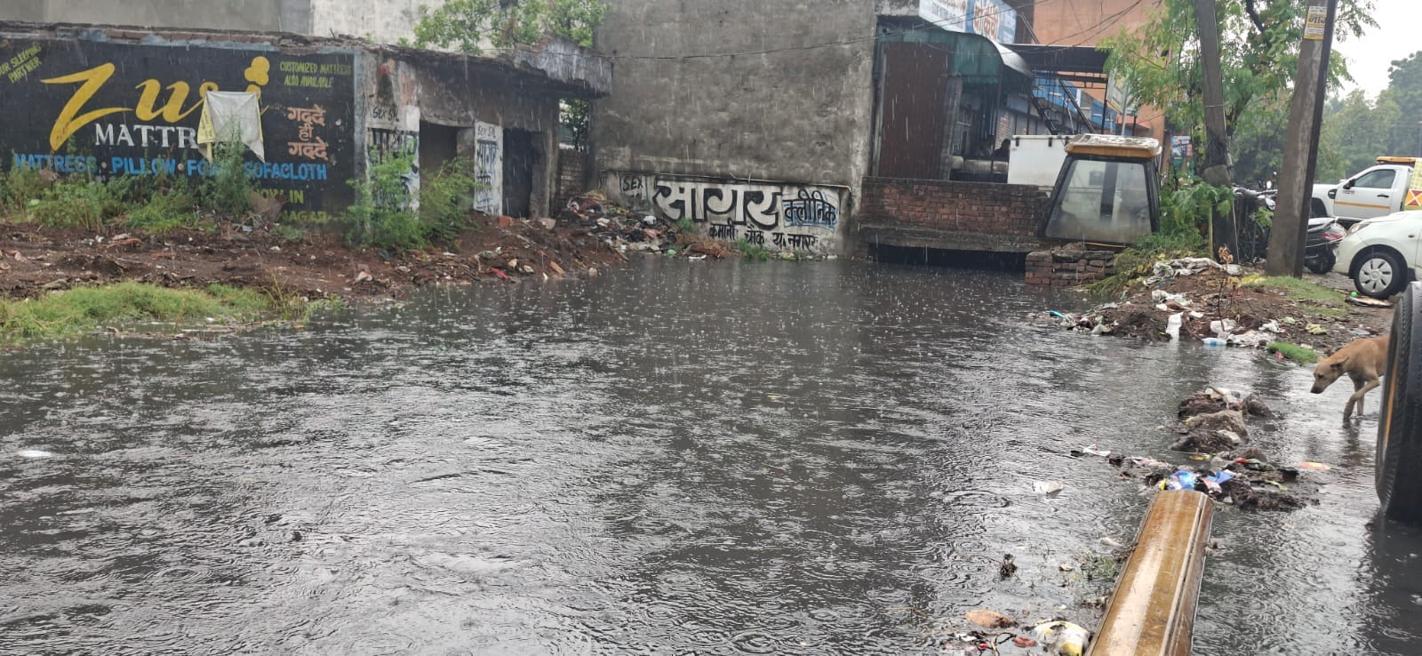 विश्वकर्मा चौक पर नाला ओवरफ्लो होने सड़क पर भरा पानी और निकलते वाहन। संवाद विश्वकर्मा चौक पर नाला ओवरफ्लो होने सड़क पर भरा पानी और निकलते वाहन। संवाद
