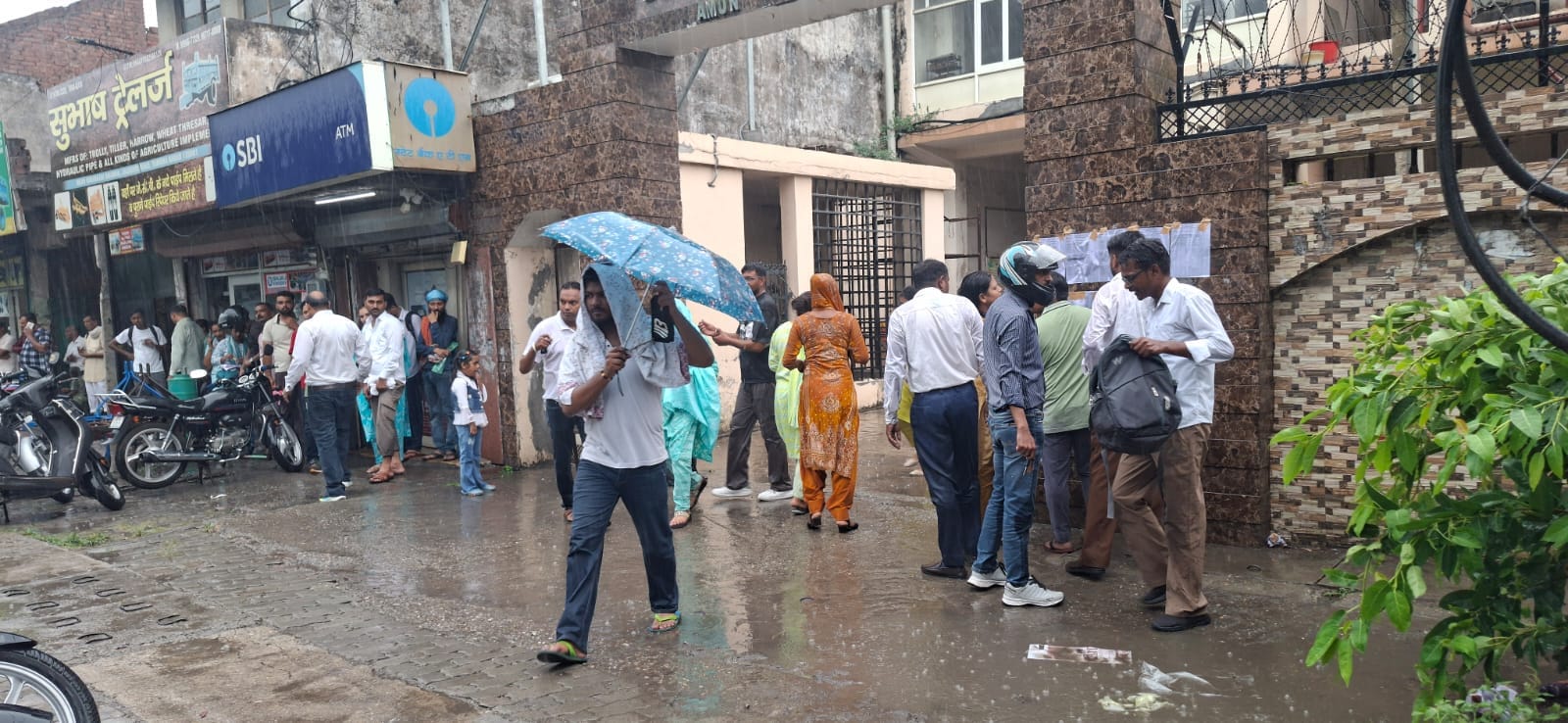 बारिश के बीच परीक्षा केंद्र पर पहुंचे अभ्यर्थी। संवाद