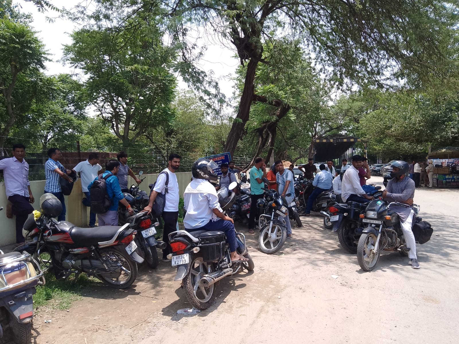 फोटो नंबर- 11तेज धूप में बंद दुकानों के बाहर परीक्षार्थियों का इंतजार करते अभिभावक। संवाद