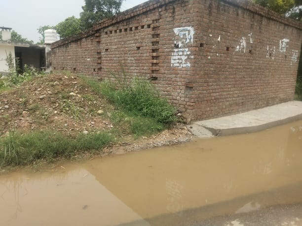 ग्राम पंचायत पंजावर निचला में ऊना गगरेट सड़क मार्ग पर जमा बरसाती पानी व मौके पर मौजूद दुकानदार।