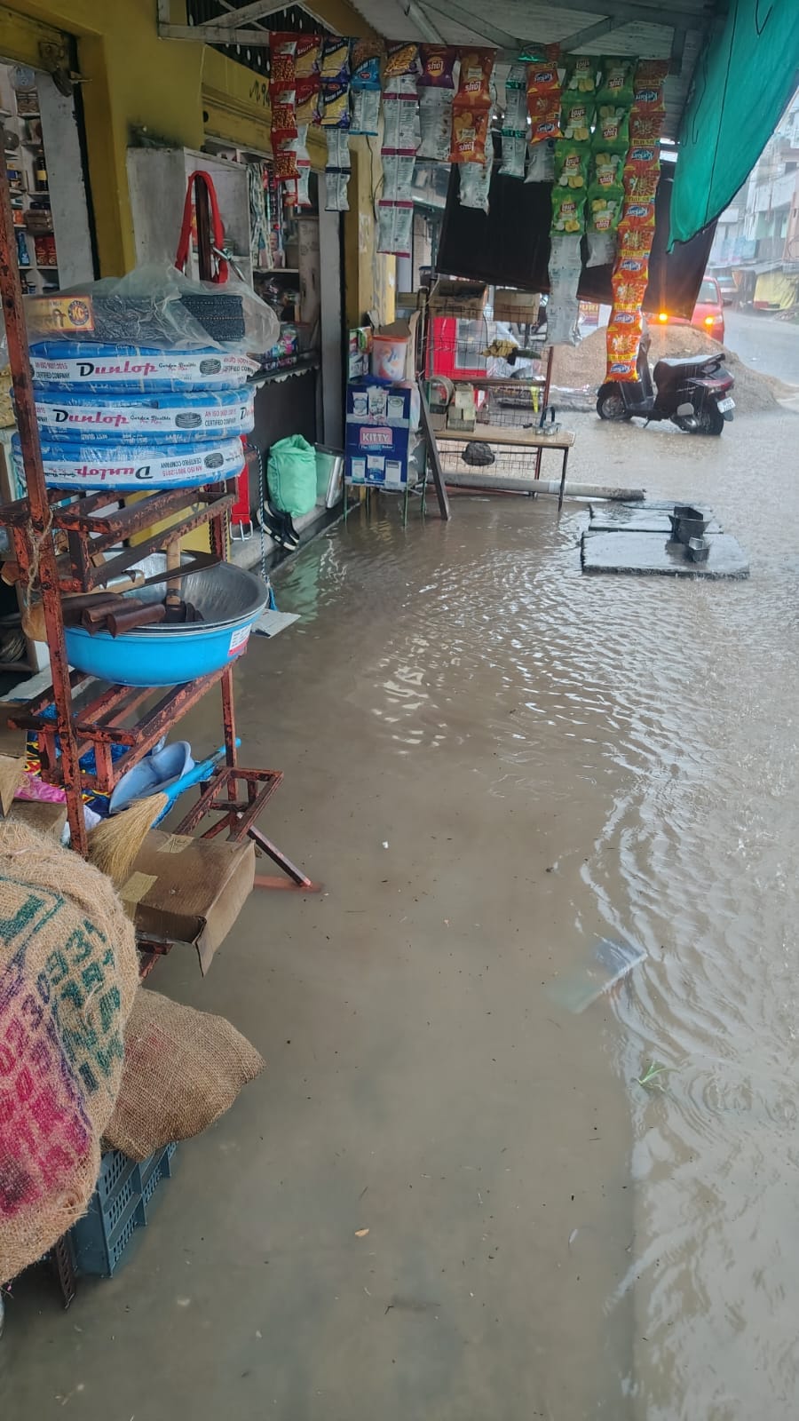 ग्राम पंचायत पंजावर निचला में ऊना गगरेट सड़क मार्ग पर जमा बरसाती पानी व मौके पर मौजूद दुकानदार।