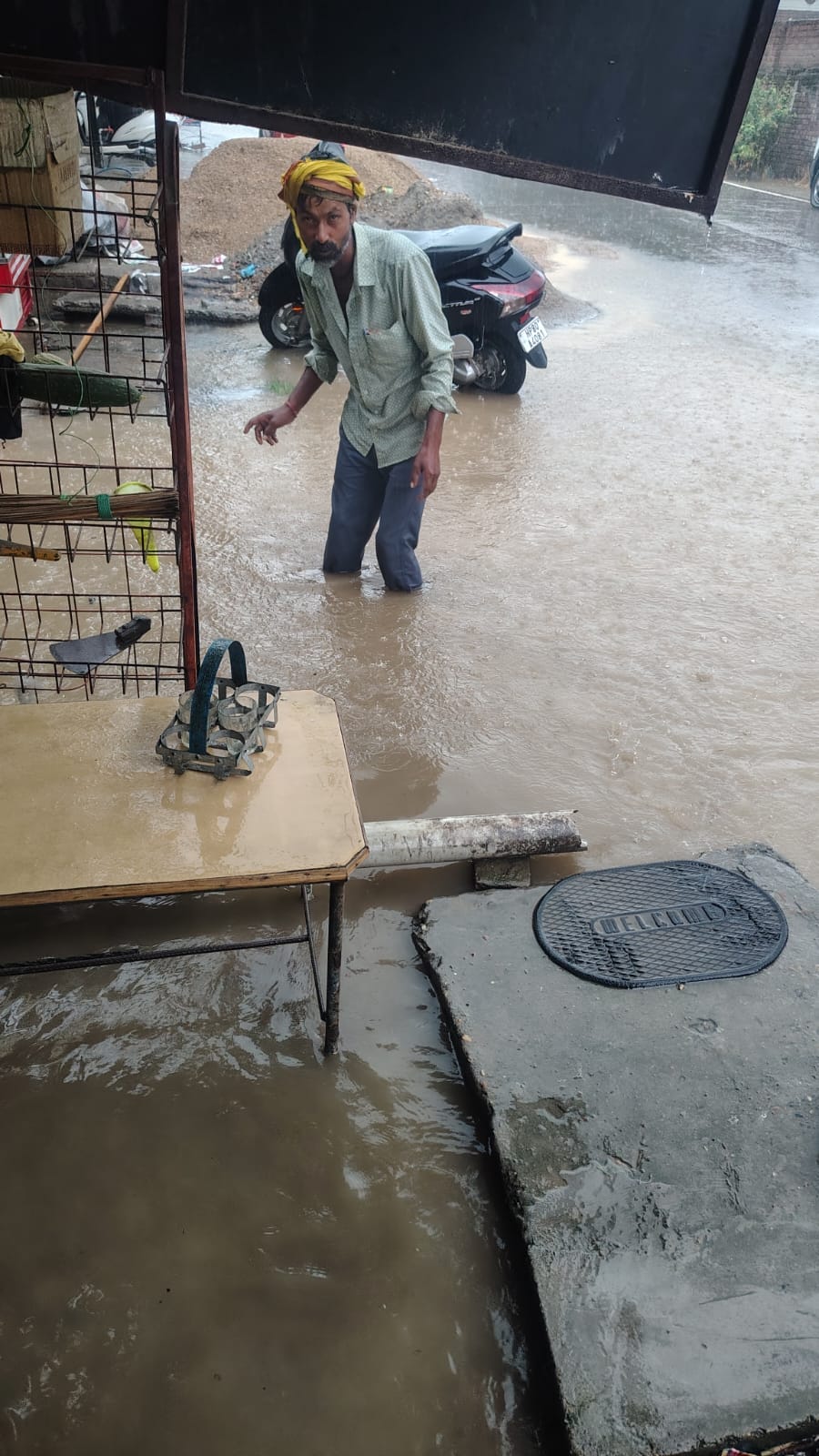 ग्राम पंचायत पंजावर निचला में ऊना गगरेट सड़क मार्ग पर जमा बरसाती पानी व मौके पर मौजूद दुकानदार।