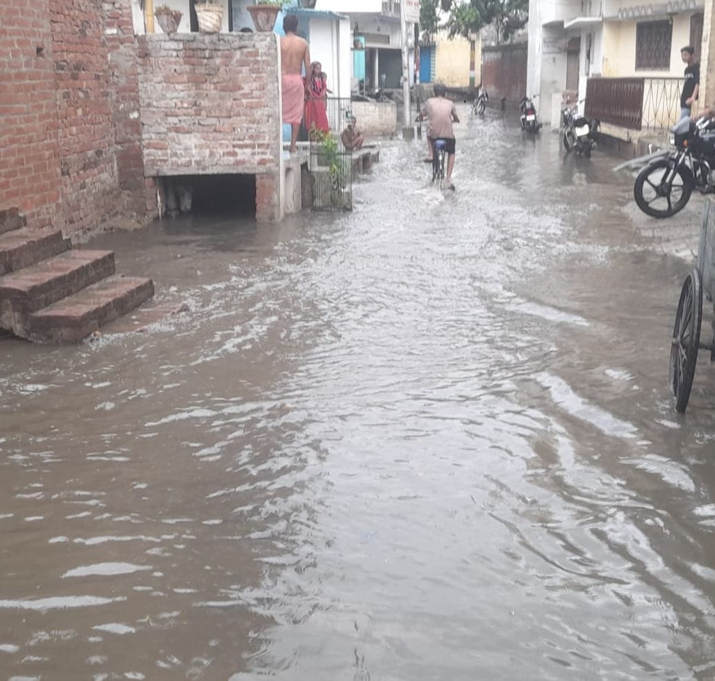 कवि तिराहा पर बारिश से हुए जलभराव में निकलते वाहन। संवाद