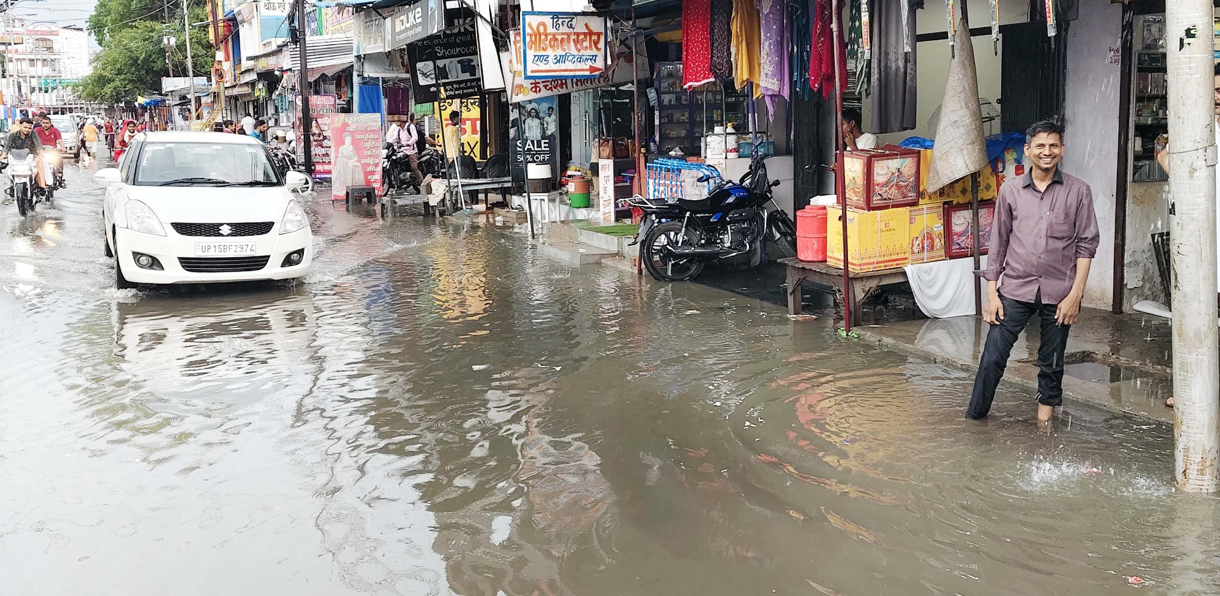 कवि तिराहा पर बारिश से हुए जलभराव में निकलते वाहन। संवाद
