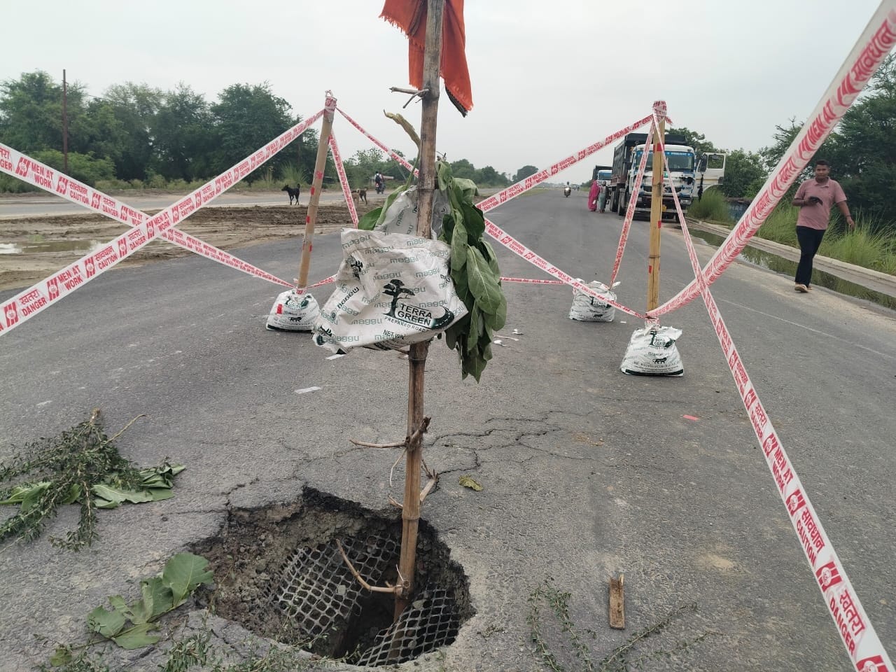 बारिश के चलते धंसा ग्रीनफील्ड एक्सप्रेस वे पर बने गड्ढा में खंभा लगाते ग्रामीण।संवाद बारिश के चलते धंसा ग्रीनफील्ड एक्सप्रेस वे पर बने गड्ढा में खंभा लगाते ग्रामीण।संवाद