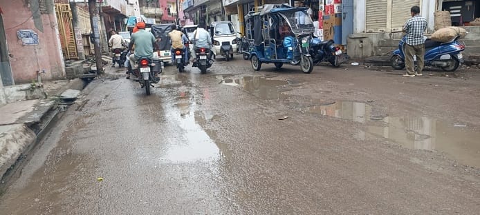 बारिश होने के बाद धान की फसल में उर्वरकों का छिड़काव करते किसान। संवाद