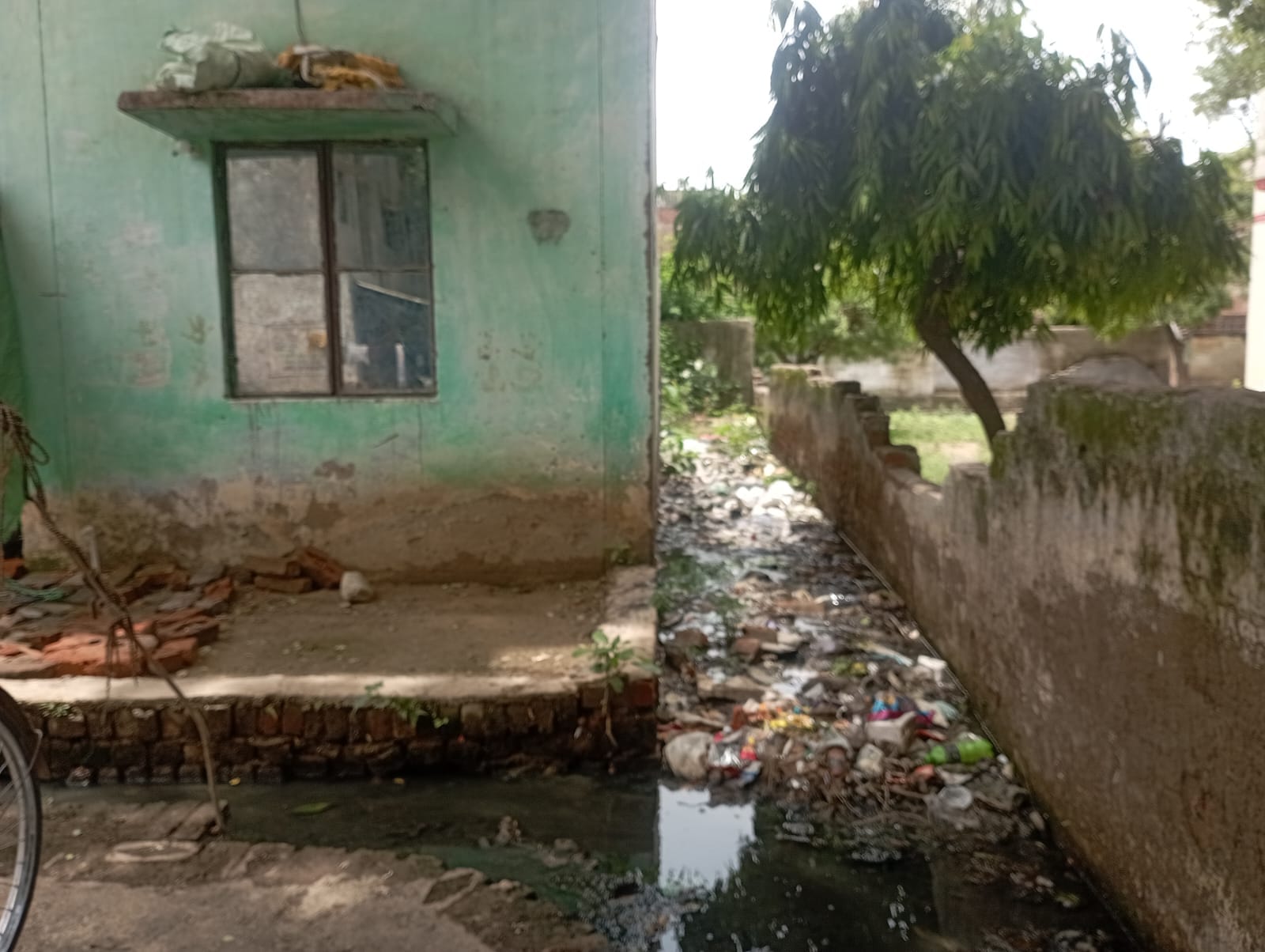 फोटो -25- कॉलोनी की बिल्डिंग से सटकर जमां कीचड़ को दिखाता युवक। संवाद फोटो -25- कॉलोनी की बिल्डिंग से सटकर जमां कीचड़ को दिखाता युवक। संवाद