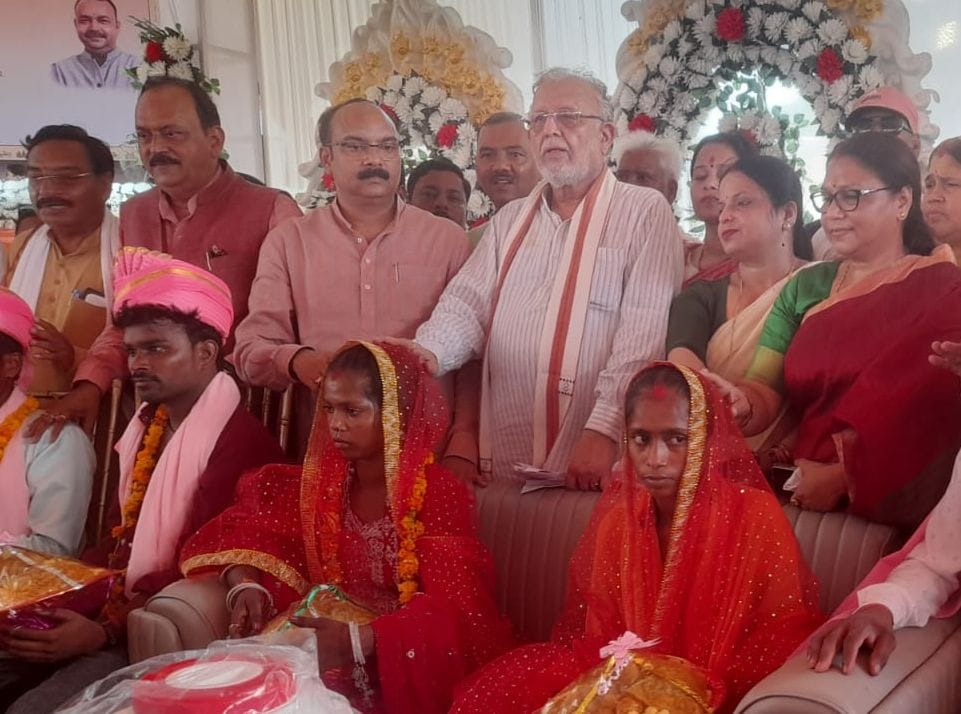 सामूहिक विवाह कार्यक्रम में गर्मी से बचाव के लिए पंखा ढुलाती नवविवाहिता। संवाद सामूहिक विवाह कार्यक्रम में गर्मी से बचाव के लिए पंखा ढुलाती नवविवाहिता। संवाद
