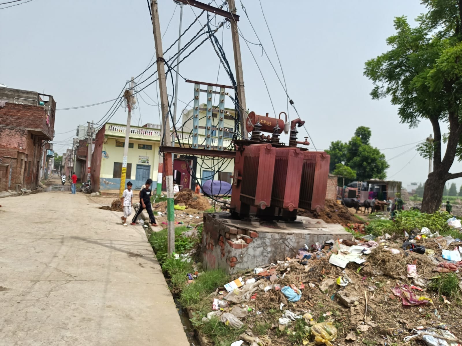 शहर के माजरा रोड स्थित देव गार्डन से आगे खुले में रखा ट्रांसफार्मर के पास से गुजरते राहगीर। सं शहर के माजरा रोड स्थित देव गार्डन से आगे खुले में रखा ट्रांसफार्मर के पास से गुजरते राहगीर। सं