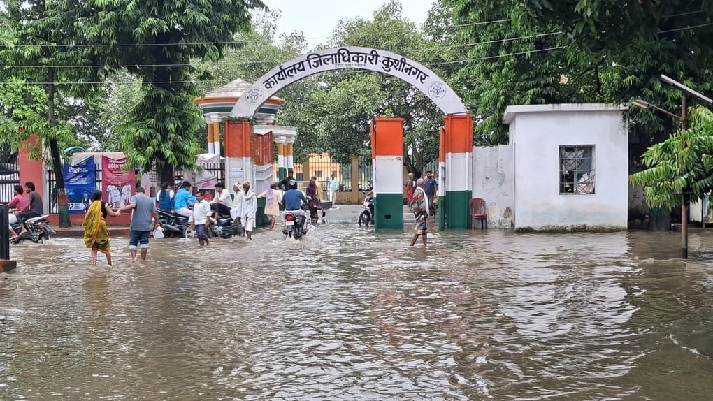 रामकोला रोड पर दुकानों में घुसे पानी को निकालने में जुटे दुकानदार। संवाद