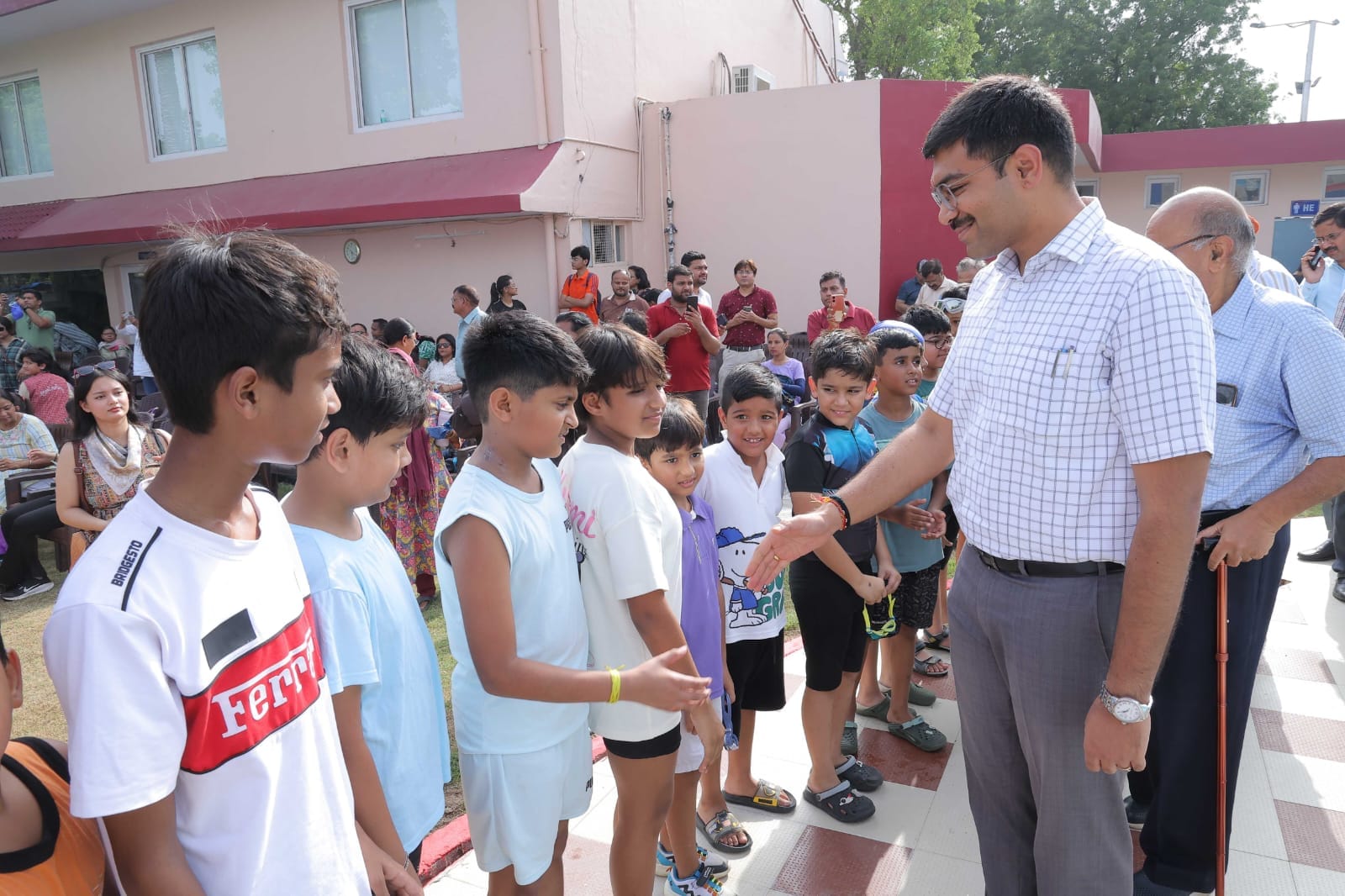 स्विमिंग प्रतियोगिता में हिस्सा लेते खिलाड़ी और हाथ मिलाते डीएम स्विमिंग प्रतियोगिता में हिस्सा लेते खिलाड़ी और हाथ मिलाते डीएम