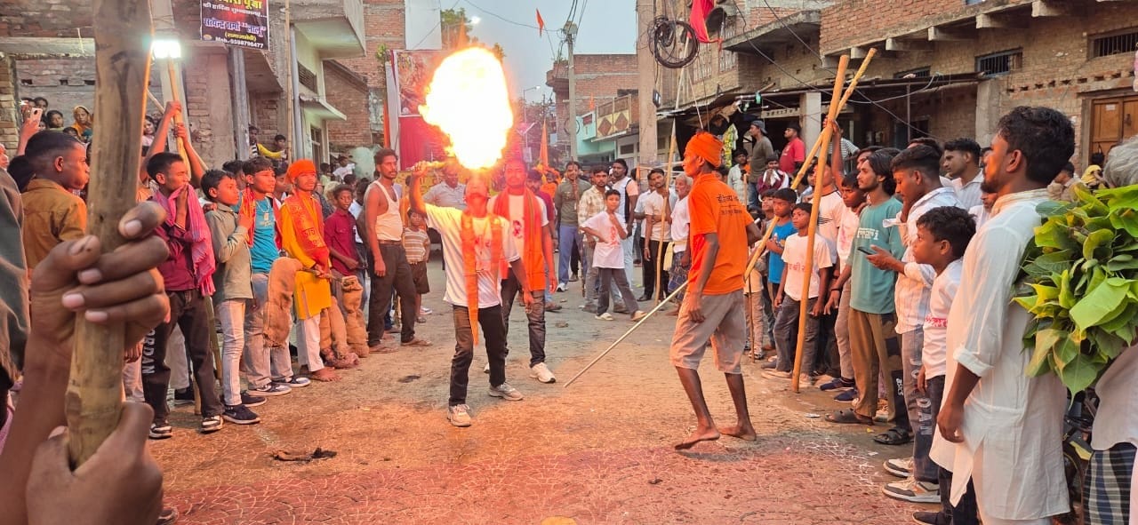 सिकंदरपुर कस्बा में निकाली गई महावीरी झंडा जुलूस में करतब दिखाते कलाकार।संवाद