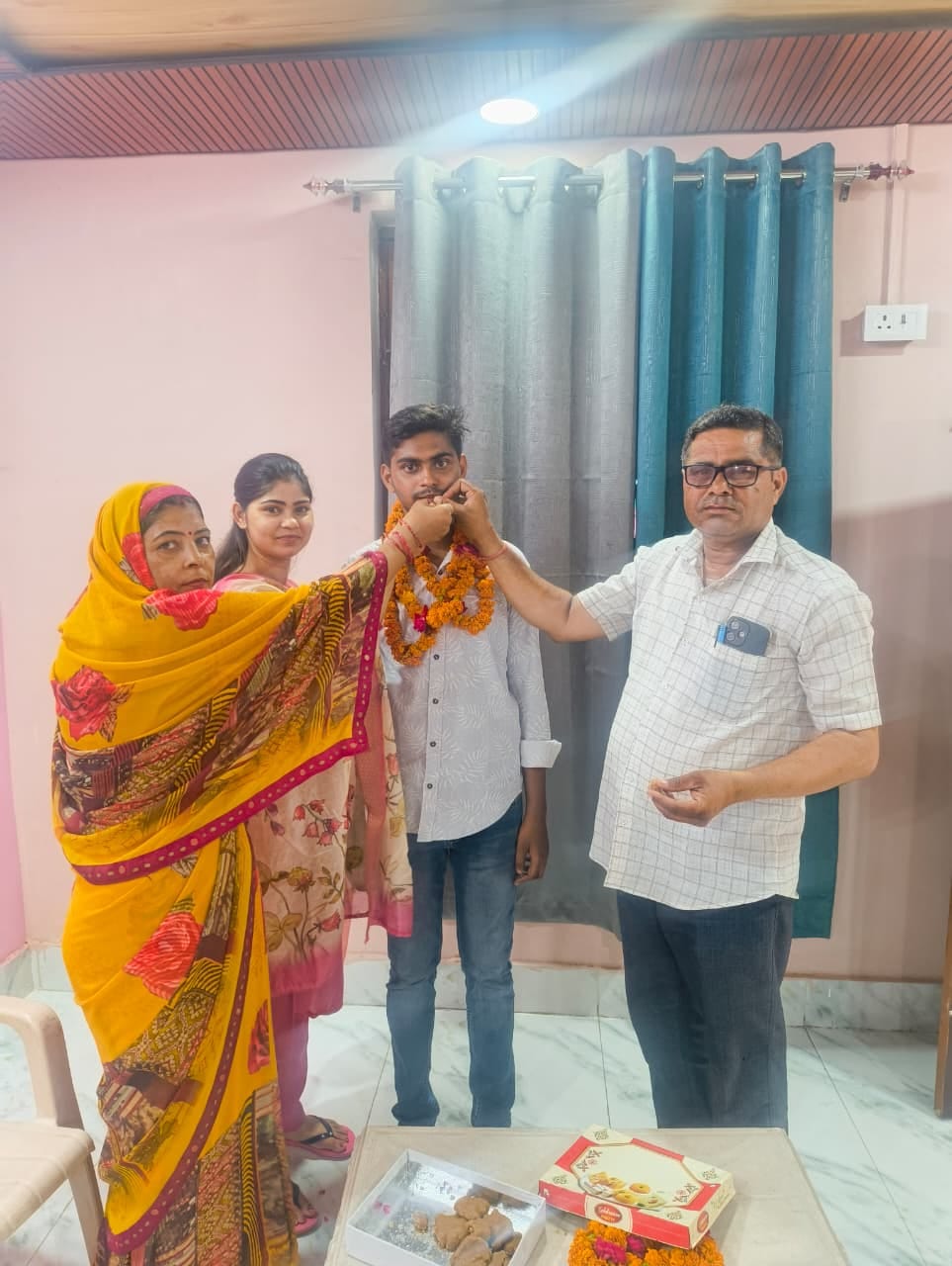 फोटो-27- देवेश को मिठाई खिलाते माता-पिता।संवाद फोटो-27- देवेश को मिठाई खिलाते माता-पिता।संवाद