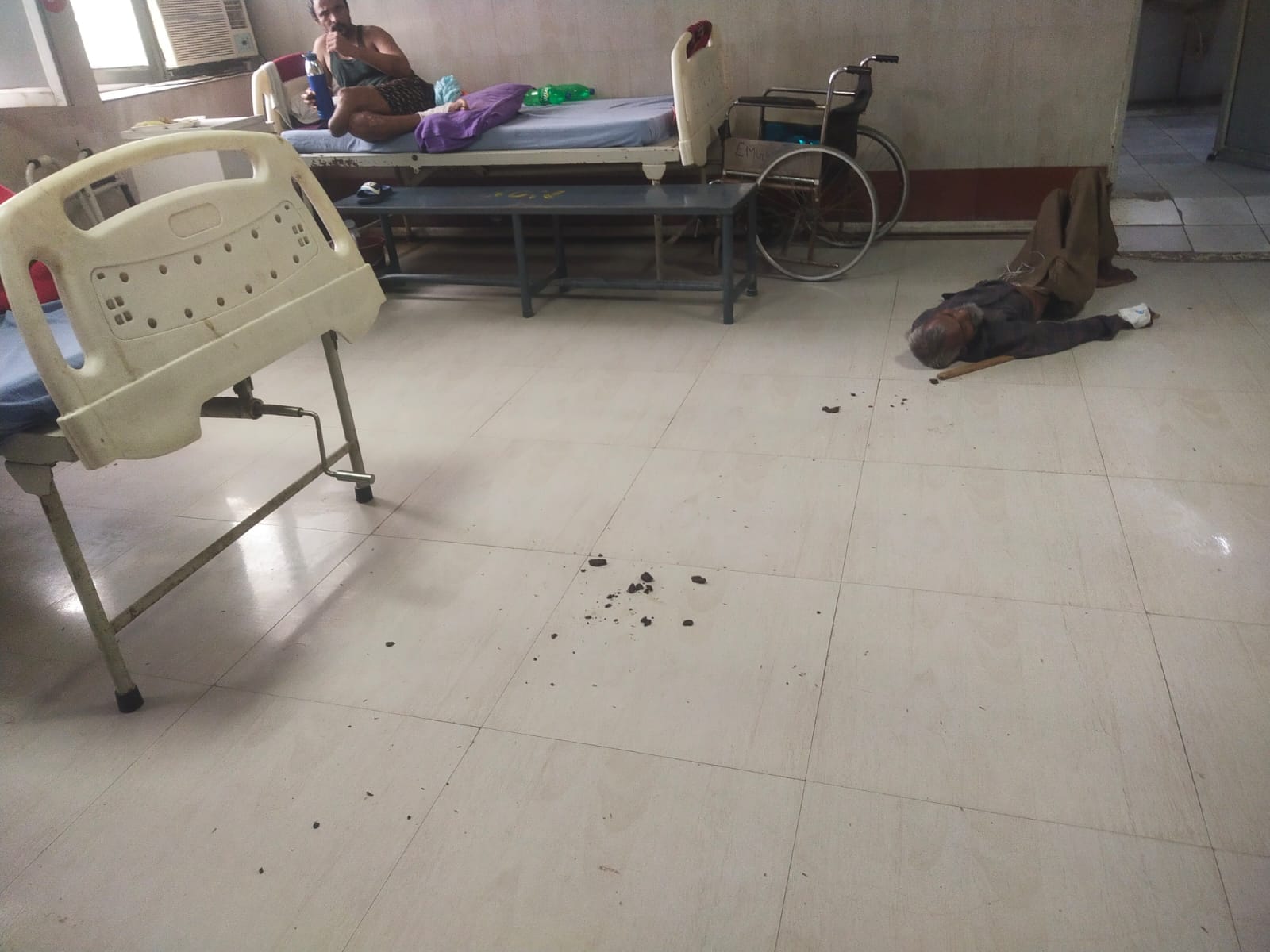 जमीन पर पड़ा मरीज। जमीन पर पड़ा मरीज।