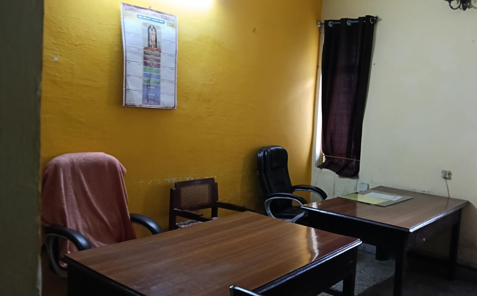 कुर्सी पर पैर रखकर बैठी महिला कर्मचारी और खाली कुर्सियां।