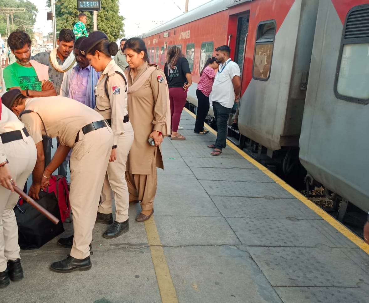 रेलवे स्टेशन पर यात्रियों से बात करते सुरक्षा कर्मी। संवाद रेलवे स्टेशन पर यात्रियों से बात करते सुरक्षा कर्मी। संवाद