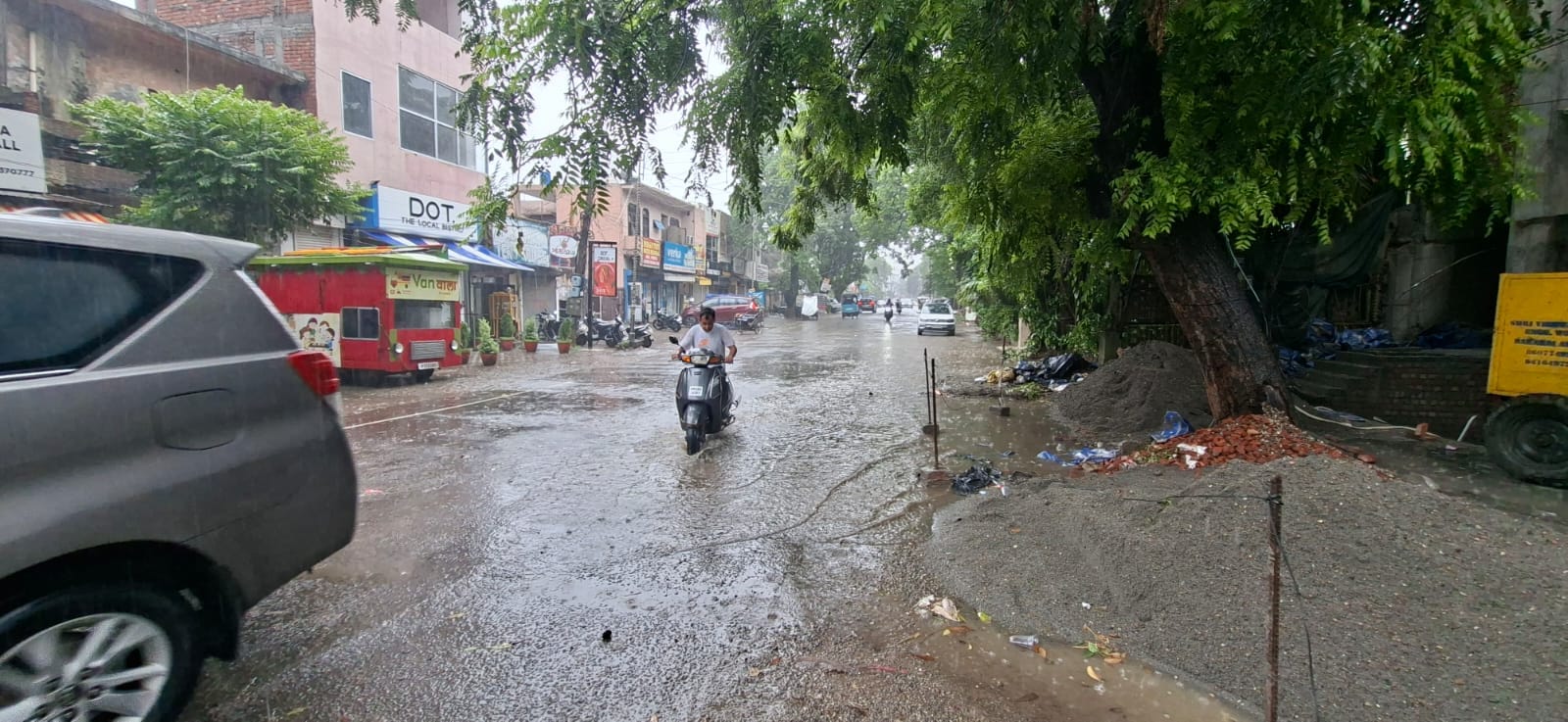 बारिश से बचने के लिए छतरी लेकर मॉडल टाउन से गुजरता व्यक्ति। संवाद बारिश से बचने के लिए छतरी लेकर मॉडल टाउन से गुजरता व्यक्ति। संवाद
