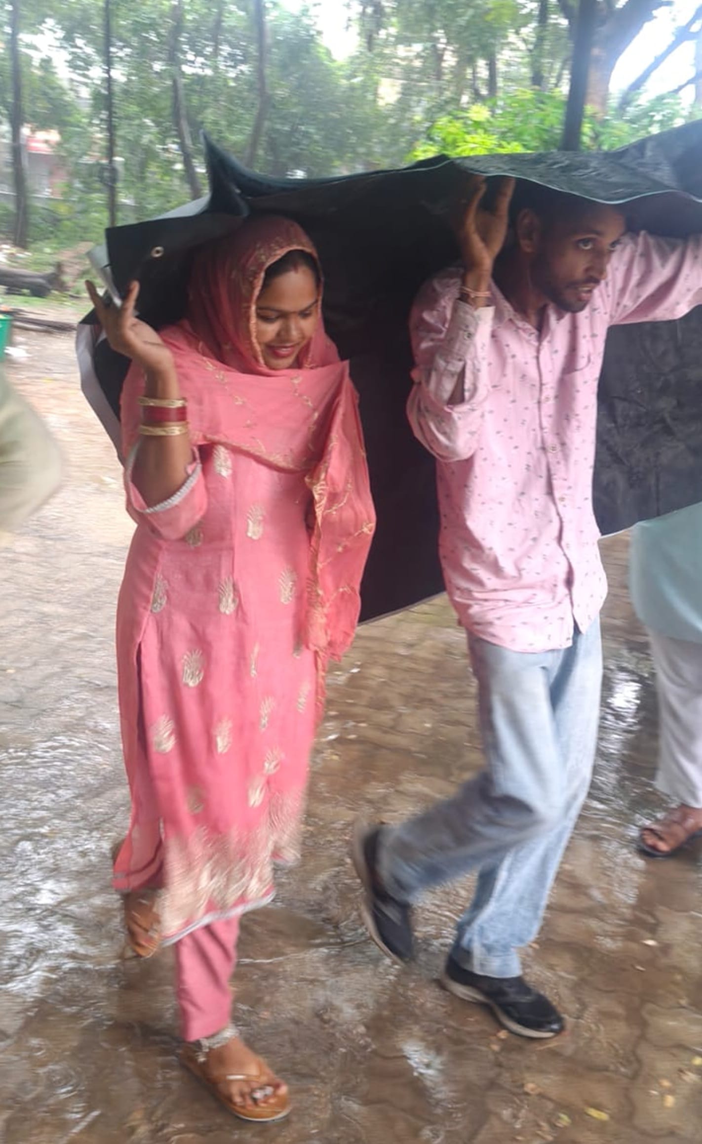 बारिश से बचने के लिए छतरी लेकर मॉडल टाउन से गुजरता व्यक्ति। संवाद बारिश से बचने के लिए छतरी लेकर मॉडल टाउन से गुजरता व्यक्ति। संवाद