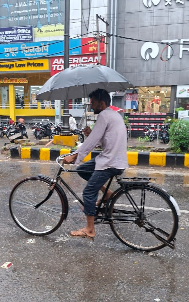 बारिश से बचने के लिए छतरी लेकर मॉडल टाउन से गुजरता व्यक्ति। संवाद बारिश से बचने के लिए छतरी लेकर मॉडल टाउन से गुजरता व्यक्ति। संवाद