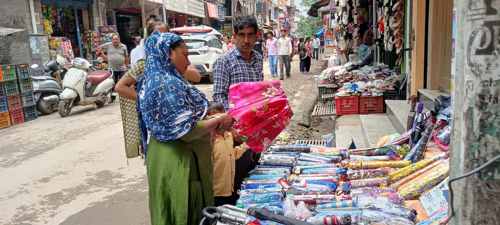 हमीरपुर बाजार में फोल्डिंग छाते की खरीदारी करते हुए युवती। संवाद हमीरपुर बाजार में फोल्डिंग छाते की खरीदारी करते हुए युवती। संवाद