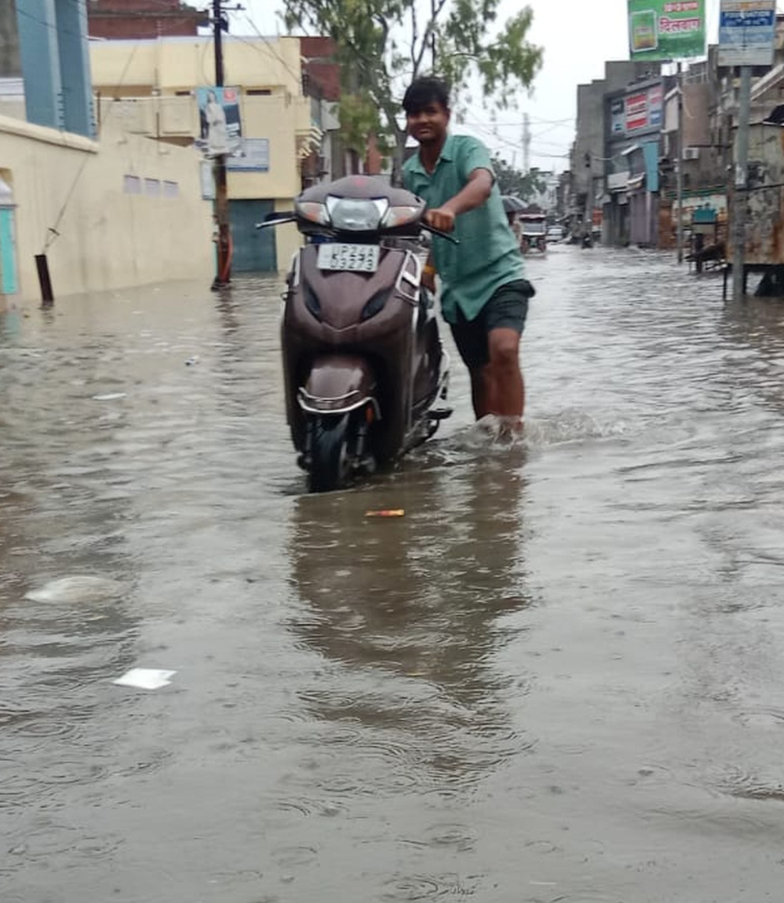 जोगीपुरा में सड़क पर भरे पानी में बंद हुए ई-रिक्शा को खींचकर ले जाते लोग।संवाद जोगीपुरा में सड़क पर भरे पानी में बंद हुए ई-रिक्शा को खींचकर ले जाते लोग।संवाद