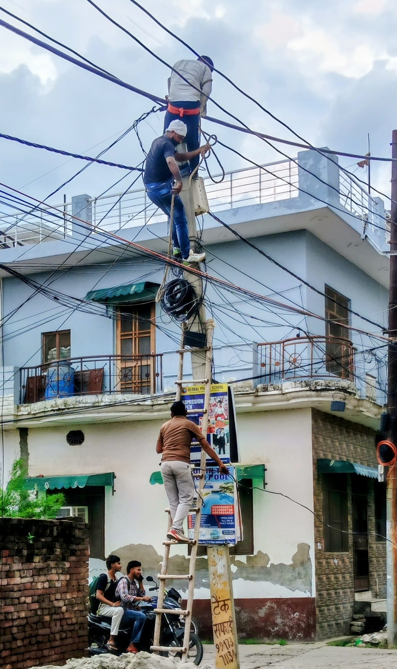 तक्षशिल कालोनी में केबल बदलते विद्युत निगम के कर्मचारी। (मवाना)