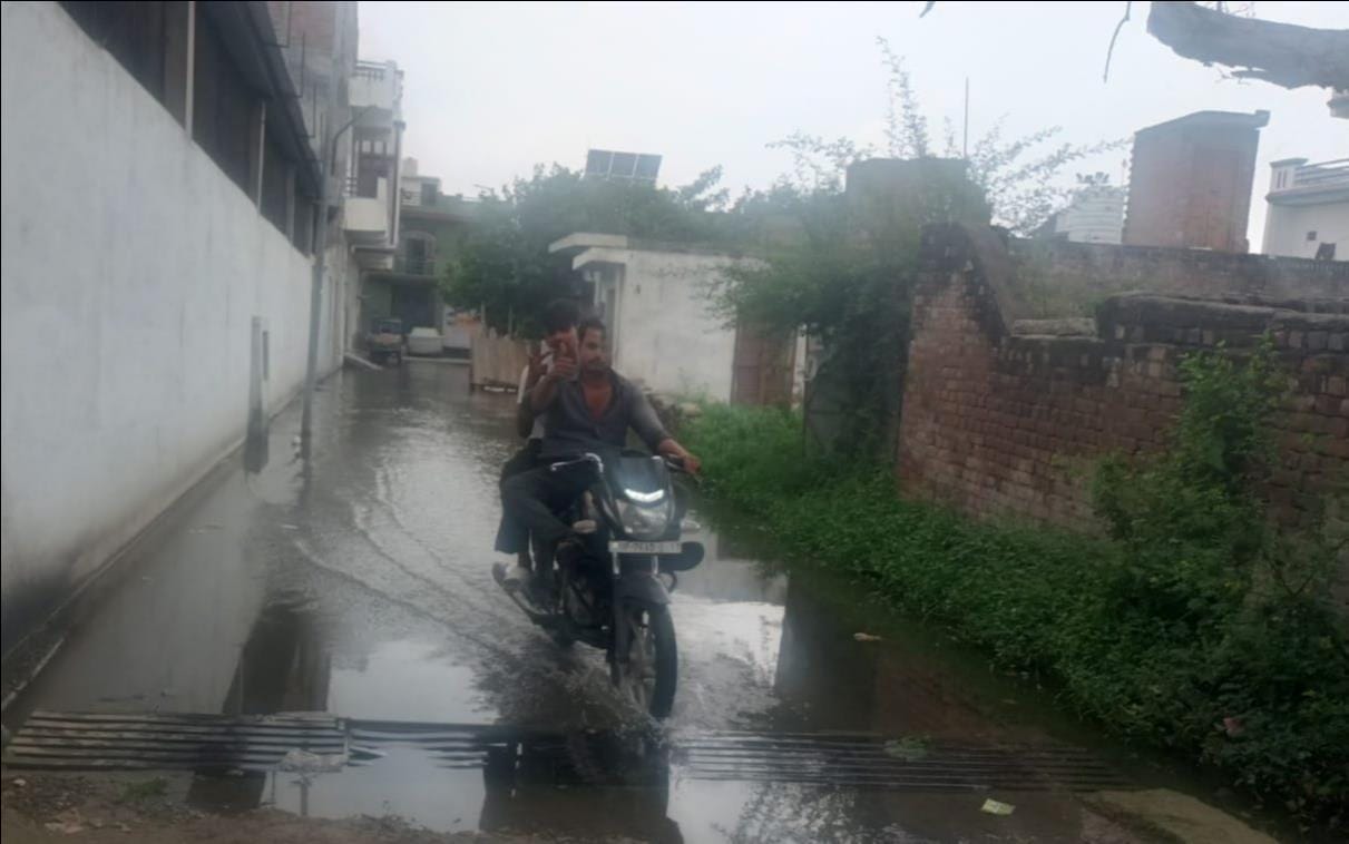 फोटो-17 बढ़पुर बगिया की गली में भरे तालाब के पानी से निकलते बेटियां। संवाद फोटो-17 बढ़पुर बगिया की गली में भरे तालाब के पानी से निकलते बेटियां। संवाद