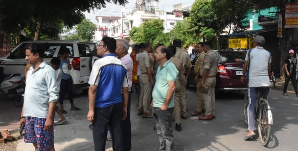 घर की छत पर बने स्टोर रूम से निकलतीं आग की लपटें व आग बुझाते दमकलकर्मी।