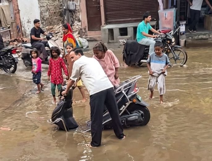 26. गड्ढे में सिस्टम...कच्चा बेरी रोड पर सीवर जाम के बाद भरा पानी। जलभराव में मैनहोल का ढक्कन ख