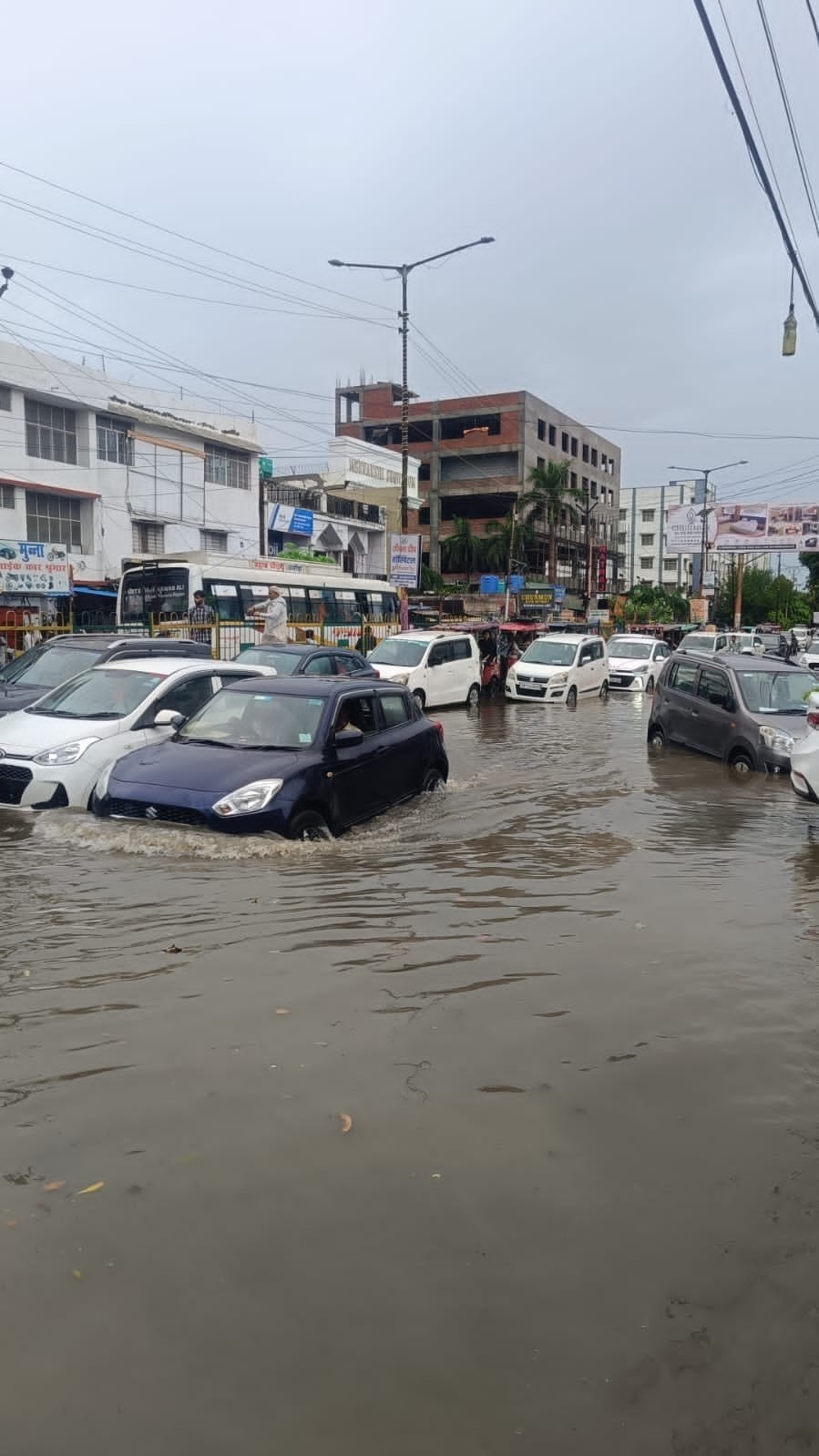 डीएम रोड पर बारिश के पानी में फंसे वाहन। संवाद डीएम रोड पर बारिश के पानी में फंसे वाहन। संवाद