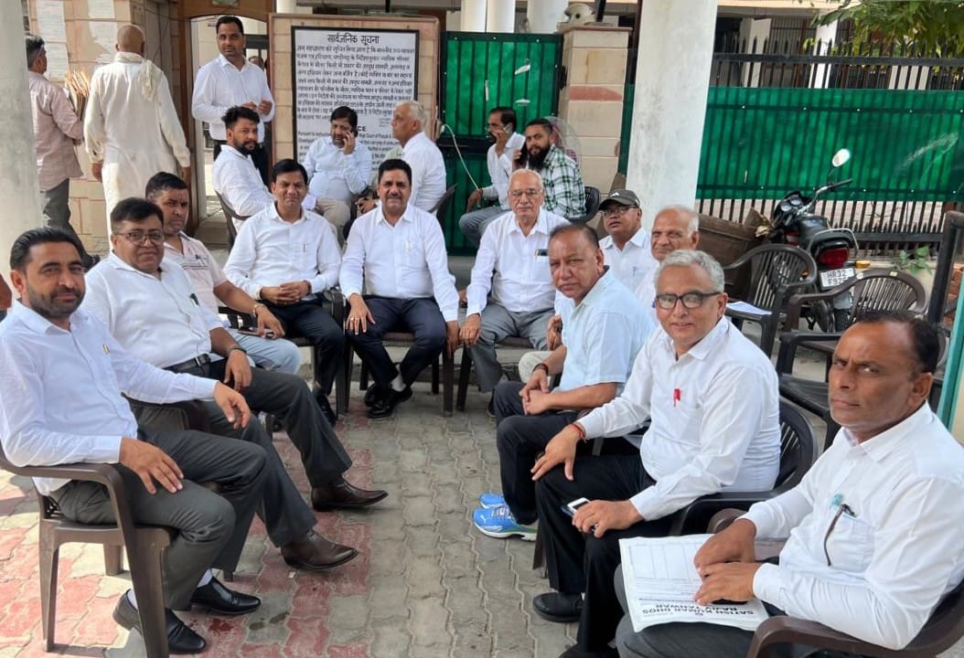 हड़ताल के बीच अदालत के द्वार पर बैठे प्रधान व अन्य वकील।