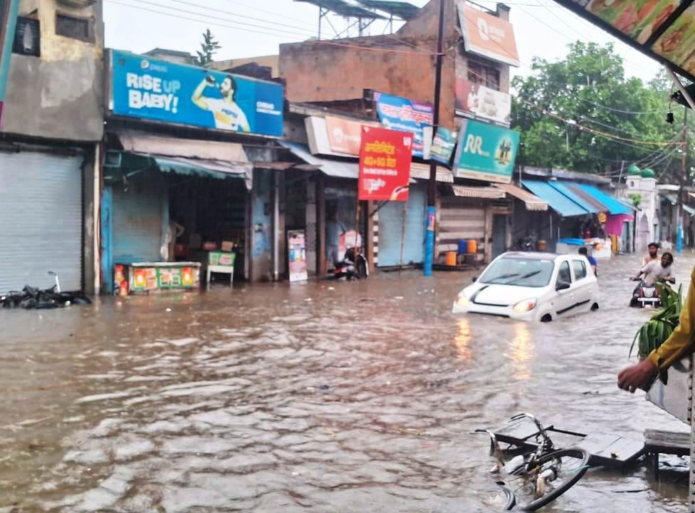 सरधना। नगर के दौराला रोड पर मंगलवार को हुई बारिश से हुए जलभराव से गुजरता वाहन चालक। संवाद सरधना। नगर के दौराला रोड पर मंगलवार को हुई बारिश से हुए जलभराव से गुजरता वाहन चालक। संवाद