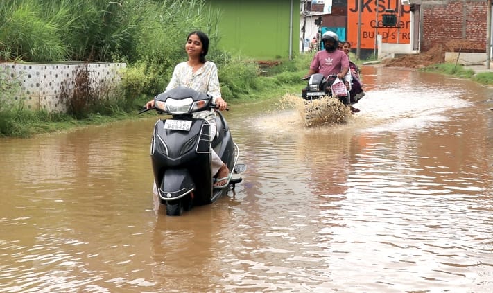 बिजनौर में बारिश से चक्कर चौराहे के पास गांव भोगी मार्ग पर हुए जलभराव से निकालते वाहन। संवाद बिजनौर में बारिश से चक्कर चौराहे के पास गांव भोगी मार्ग पर हुए जलभराव से निकालते वाहन। संवाद