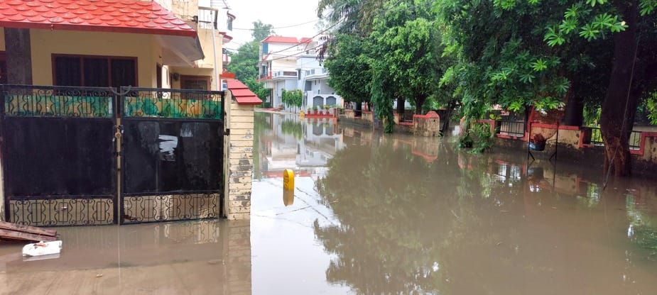 बिजनौर में बारिश से चक्कर चौराहे के पास गांव भोगी मार्ग पर हुए जलभराव से निकालते वाहन। संवाद बिजनौर में बारिश से चक्कर चौराहे के पास गांव भोगी मार्ग पर हुए जलभराव से निकालते वाहन। संवाद